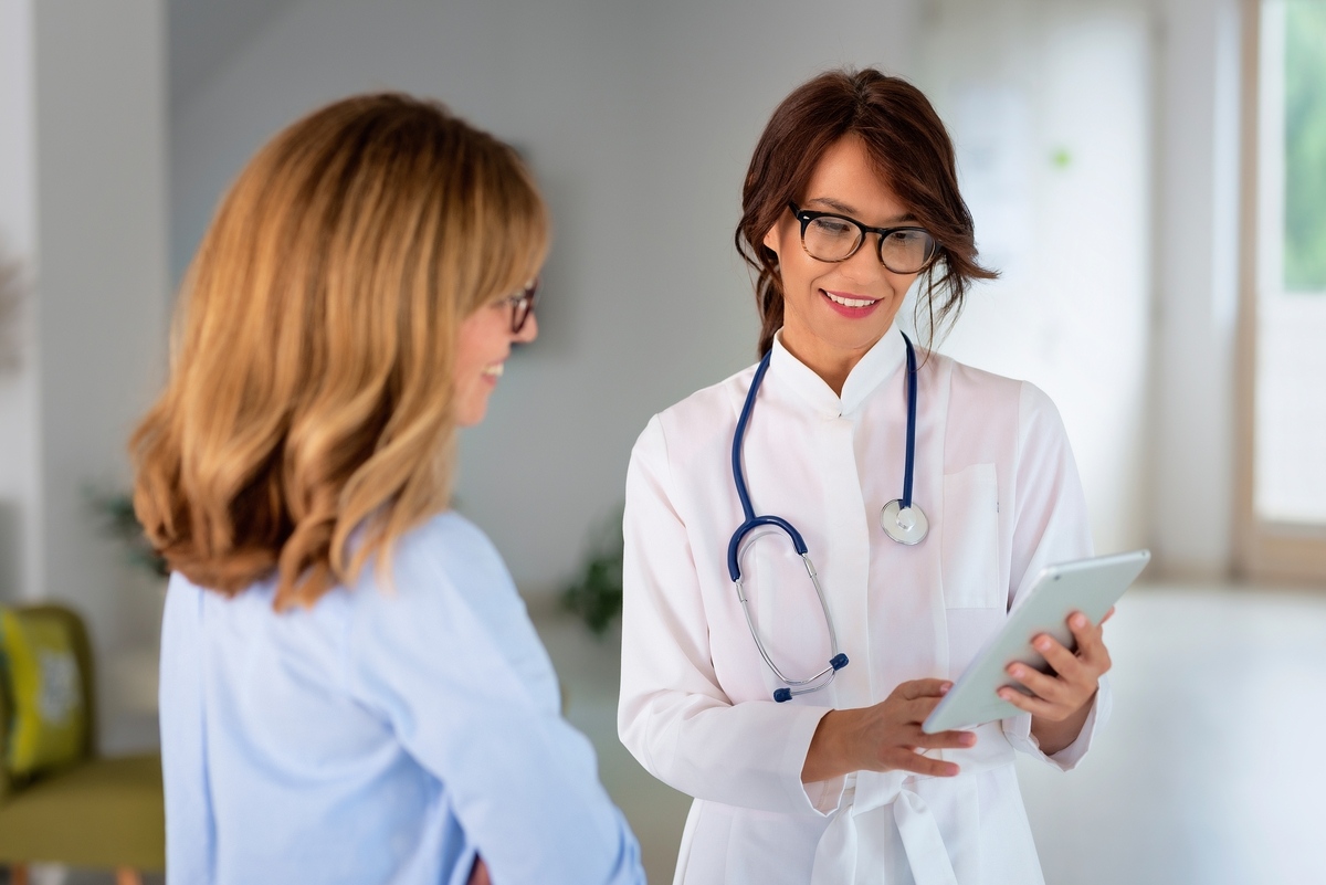 Woman discussing HRT in Strongsville, OH with a provider reviewing her results on a tablet