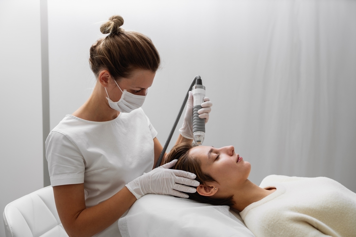 Provider performing Luxora skin tightening treatment with RF device on patient's face