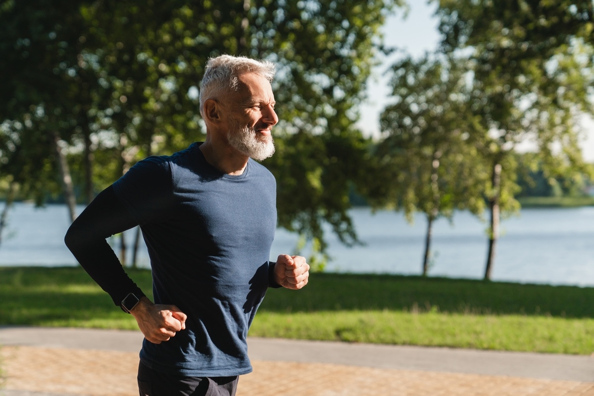 Active middle-aged man jogging in a park, representing men exploring TRT in Strongsville, OH