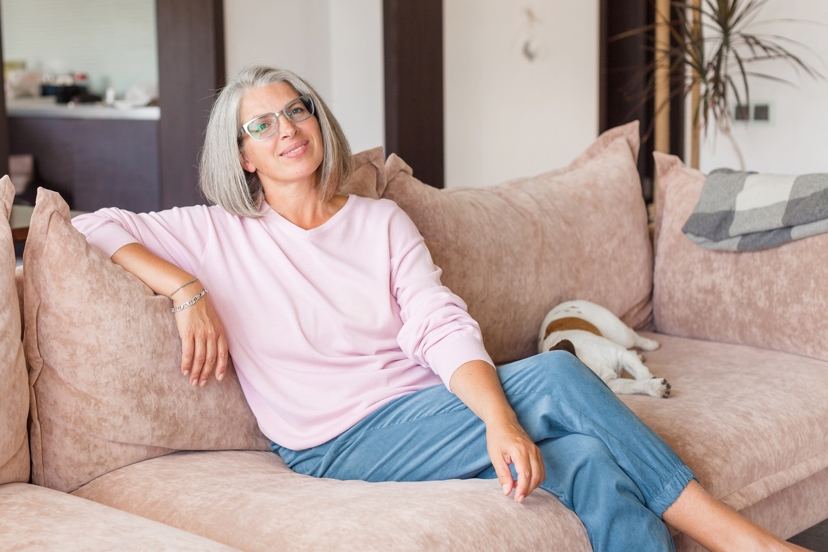 Gray-haired woman relaxing on a sofa at home, illustrating Hormone Replacement Therapy in Medina, OH.