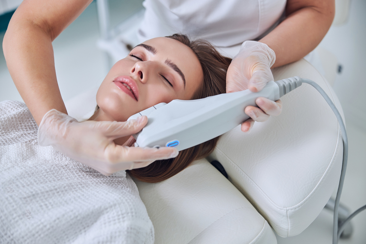 Provider performing non-surgical skin tightening in Medina, OH on a woman's jawline and cheek